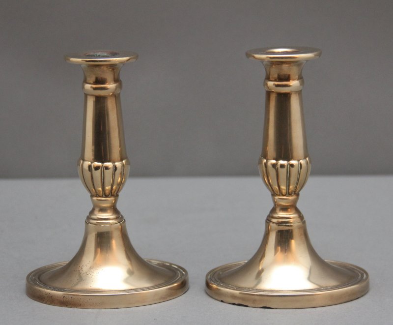 A pair of brass Georgian candlesticks