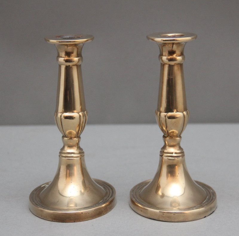 A pair of brass Georgian candlesticks