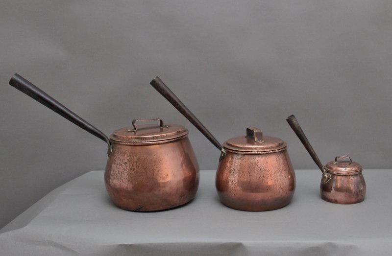 A set of three Victorian copper saucepans