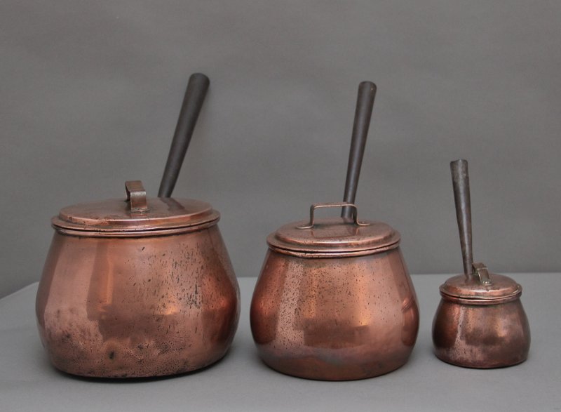 A set of three Victorian copper saucepans