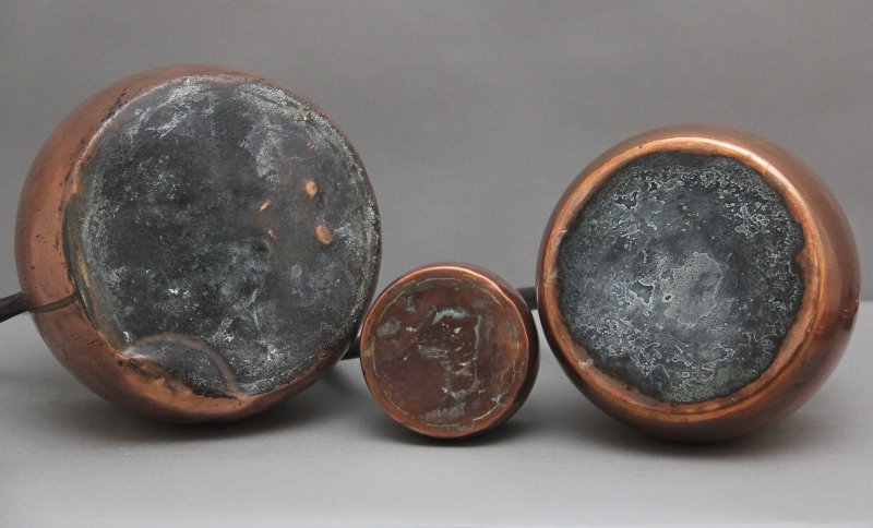 A set of three Victorian copper saucepans